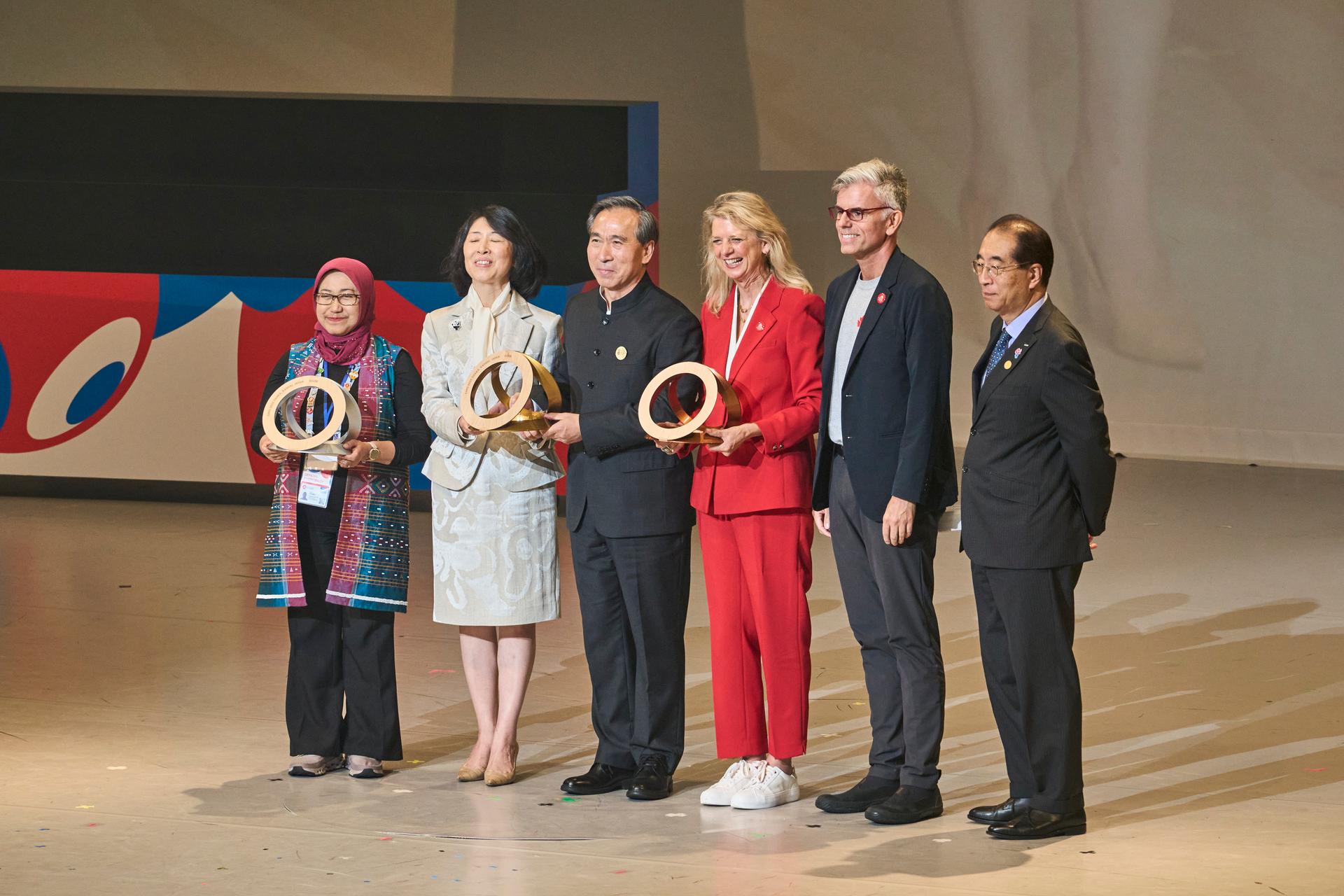 Expo Osaka team accepting a trophy on stage